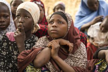 Two young niger woman listening in group.