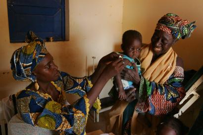 A mother holds her young child at a nutritional screening center in niger