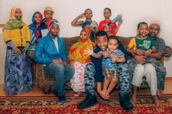 Abdullahi with several family members gathered on and around a couch