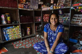 A young woman dressed in blue in her shop in nepal, which she opened with the help of a small loan from a mercy corps microfinance partner there.