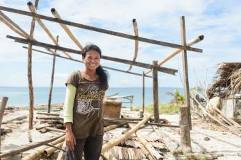 A pregnant woman stands in front of her house in the phillipines, which was destroyed during typhoon haiyan 