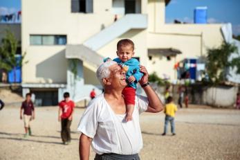 Baby on shoulders of smiling man in greece