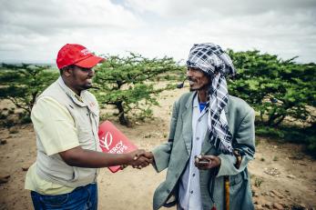 Mercy corps employee shaking hands with man in ethiopia