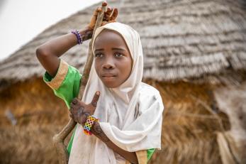 Child in Niger wearing colorful bracelets and a scarf