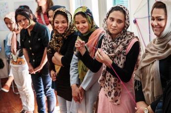Several teen girl refugees standing next to each other smiling