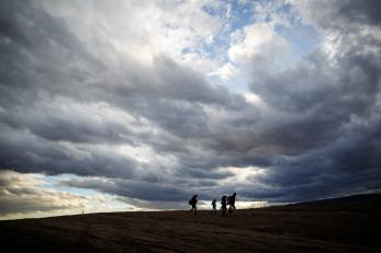 People walking with cloudy sky behind them in Serbia