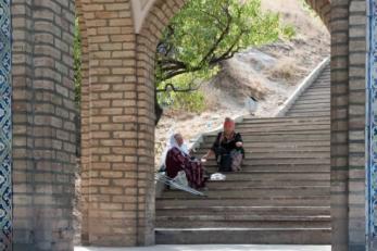 two people sitting on stairs outside