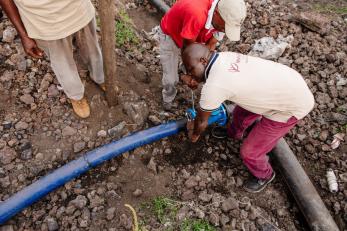 Men work to connect water pipes in DR Congo