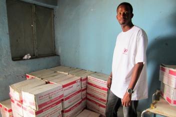 Mercy Corps nurse Abdullahi Mohammed picks up boxes of Plumpy-Nut to bring on a mobile health visit. The high-protein supplement is given to malnourished children on the spot and sent home with mothers.